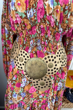 Colorful boho floral dress with decorative buttons on a plain background