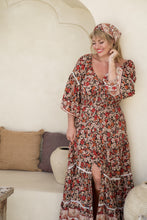 Women wearing bohemian floral  maxi dress 3/4 sleeve with white hat flowy dress in beige background side view