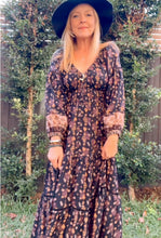 Woman in a floral boho dress IN OUTDOOR BACKYARD.
