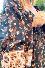 A woman wearing boho dress close up lok of the sleeves.
