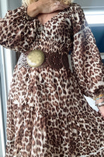 Person wearing a boho leopard print dress with a large belt buckle.