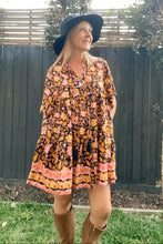 Woman wearing a boho floral dress and hat outdoors
