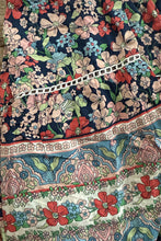 Stack of floral-patterned fabric with a mix of colors including blue, red, and green.