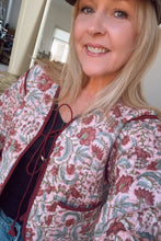 Woman wearing a boho patterned jacket indoors