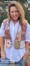 Woman wearing a patterned vest over a white shirt outdoors