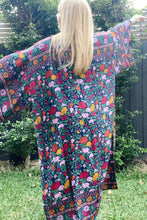 Person wearing a colorful boho floral kimono with a garden background