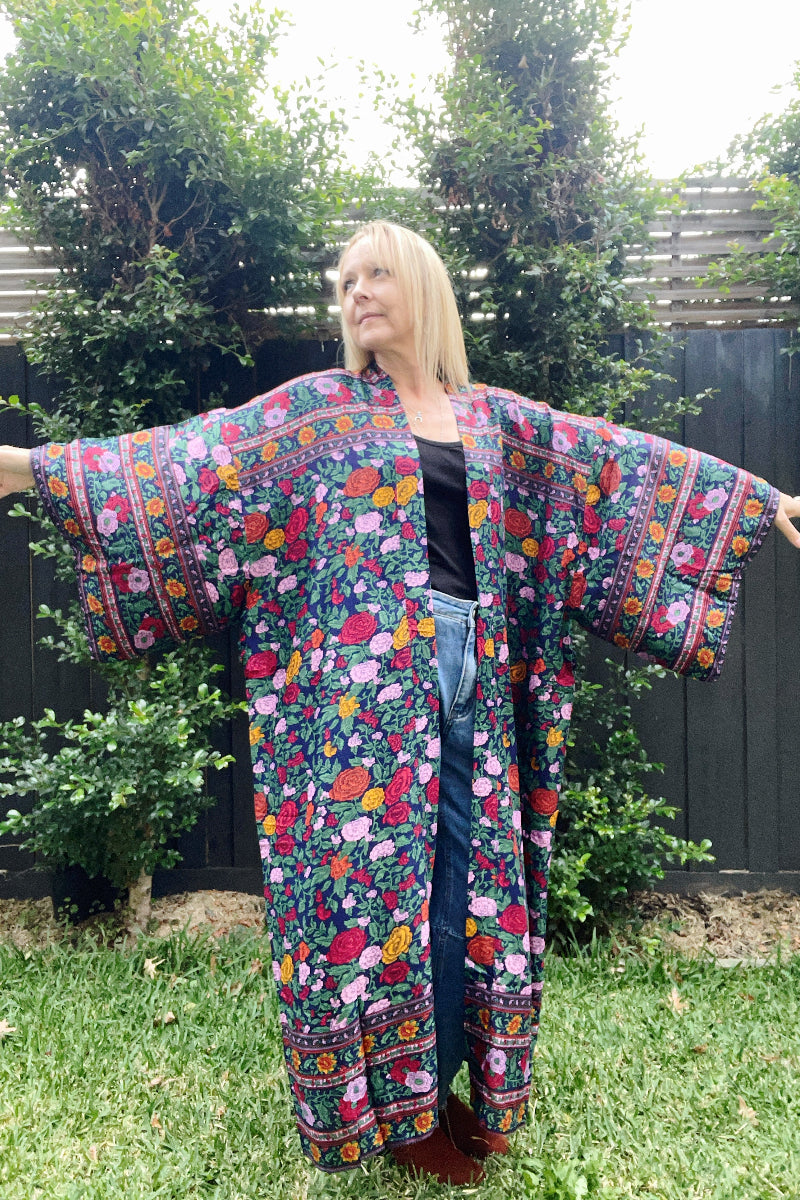 Woman wearing a colorful floral boho kimono in an outdoor setting