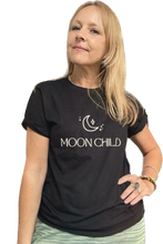 Woman wearing a black boho t-shirt with 'MOON CHILD' text and moon graphic on a white background
