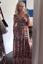 Woman taking a mirror selfie wearing a BOHO floral dress in an indoor setting.