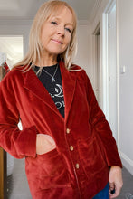Woman wearing a red velvet boho coat indoors