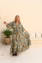 Woman wearing a floral boho dress in a living room setting