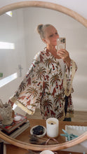 Person wearing a boho patterned kimono in front of a mirror