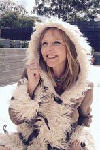 Woman wearing a boho fluffy beige hooded coat outdoors