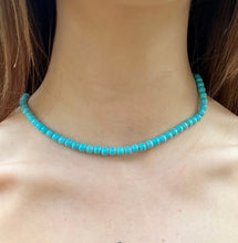 Turquoise beaded boho necklace on a person's neck with blurred background