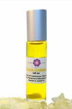 Roll-on bottle with yellow liquid and silver cap on a white background