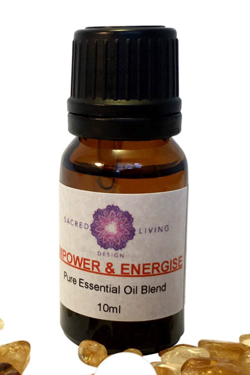 A bottle of 'Essential Oil Blend' with a label that reads 'Power & Energy' and a small crystal figure beside it, on a white background.