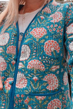Floral patterned jacket with pink and white flowers on a blue background